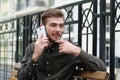 Young handsome businessman sits on bench and speaks on cell phone Royalty Free Stock Photo