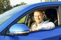 Successfull happy young man and his car in soft sunset light on urbanistic background. Busines man with vehicle on roadside. Royalty Free Stock Photo