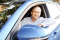 Successfull happy young man and his car in soft sunset light on urbanistic background. Busines man with vehicle on roadside. Royalty Free Stock Photo