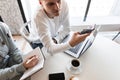 Young handsome businessman sitting at the table in the office at a business meeting with a colleague using a mobile phone Royalty Free Stock Photo