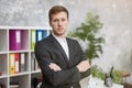 Young handsome businessman in smart jacket standing in his modern office. multitasking, work concept Royalty Free Stock Photo