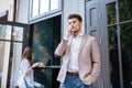 Young handsome businessman talking on mobile phone outdoors at cafe Royalty Free Stock Photo