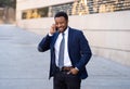 Young handsome businessman using mobile phone app sending message outside office in urban city Royalty Free Stock Photo