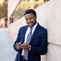 Young handsome businessman using mobile phone app sending message outside office in urban city Royalty Free Stock Photo