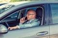 Young handsome businessman using mobile phone while driving car to work Royalty Free Stock Photo