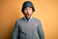 Young handsome businessman wearing military helmet over isolated yellow background afraid and shocked with surprise expression, Royalty Free Stock Photo