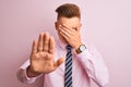 Young handsome businessman wearing shirt and tie standing over isolated pink background covering eyes with hands and doing stop Royalty Free Stock Photo