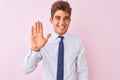 Young handsome businessman wearing shirt and tie standing over isolated pink background Waiving saying hello happy and smiling, Royalty Free Stock Photo