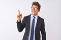 Young handsome businessman wearing suit and glasses over isolated white background with a big smile on face, pointing with hand Royalty Free Stock Photo