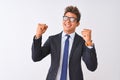 Young handsome businessman wearing suit and glasses over isolated white background very happy and excited doing winner gesture Royalty Free Stock Photo
