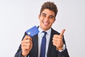 Young handsome businessman wearing suit holding credit card over isolated white background happy with big smile doing ok sign, Royalty Free Stock Photo