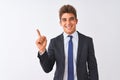 Young handsome businessman wearing suit standing over isolated white background with a big smile on face, pointing with hand and Royalty Free Stock Photo