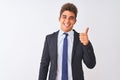 Young handsome businessman wearing suit standing over isolated white background doing happy thumbs up gesture with hand Royalty Free Stock Photo