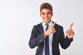 Young handsome businessman wearing suit standing over isolated white background smiling and looking at the camera pointing with Royalty Free Stock Photo