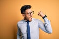 Young handsome businessman wearing tie and glasses standing over yellow background Dancing happy and cheerful, smiling moving Royalty Free Stock Photo