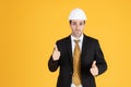 Young handsome businessman wears suit and construction helmet