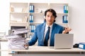The young handsome busy employee sitting in office Royalty Free Stock Photo