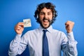 Young handsome call center agent man with beard working using headset holding help reminder screaming proud and celebrating Royalty Free Stock Photo