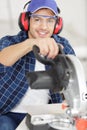 young handsome carpenter with glasses uses circular saw Royalty Free Stock Photo