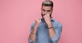 young handsome casual man against pink studio background