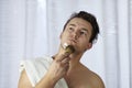 Young handsome caucasian man begins to shave with brush and foam, vintage style of old barber. Thoughtful serious look Royalty Free Stock Photo