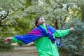 Young handsome caucasian man with bright freaky sportswear 70s style stands at a morning park. Stick in the mouth, golden glasses, Royalty Free Stock Photo