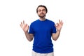 young handsome caucasian man with dark well-groomed hair and beard dressed in a blue t-shirt