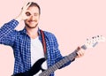 Young handsome caucasian man playing electric guitar smiling happy doing ok sign with hand on eye looking through fingers Royalty Free Stock Photo