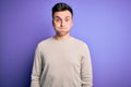 Young handsome caucasian man wearing casual sweater over purple isolated background puffing cheeks with funny face Royalty Free Stock Photo