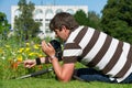 Young handsome caucasian photographer/videographer in botanic gardens.