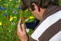 Young handsome caucasian photographer/videographer in botanic gardens.