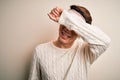 Young handsome chinese man injured for accident wearing bandage and strips on head covering eyes with arm smiling cheerful and