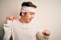 Young handsome chinese man injured for accident wearing bandage and strips on head Dancing happy and cheerful, smiling moving