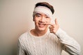 Young handsome chinese man injured for accident wearing bandage and strips on head Pointing with hand finger to face and nose, Royalty Free Stock Photo