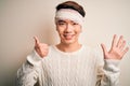 Young handsome chinese man injured for accident wearing bandage and strips on head showing and pointing up with fingers number six Royalty Free Stock Photo