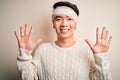 Young handsome chinese man injured for accident wearing bandage and strips on head showing and pointing up with fingers number ten Royalty Free Stock Photo