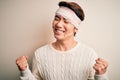 Young handsome chinese man injured for accident wearing bandage and strips on head very happy and excited doing winner gesture