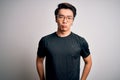 Young handsome chinese man wearing black t-shirt and glasses over white background depressed and worry for distress, crying angry Royalty Free Stock Photo