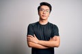 Young handsome chinese man wearing black t-shirt and glasses over white background skeptic and nervous, disapproving expression on Royalty Free Stock Photo