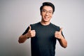 Young handsome chinese man wearing black t-shirt and glasses over white background success sign doing positive gesture with hand, Royalty Free Stock Photo