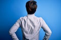 Young handsome chinese man wearing casual shirt standing over isolated blue background standing backwards looking away with arms Royalty Free Stock Photo