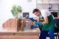 Young handsome contractor cleaning the office Royalty Free Stock Photo