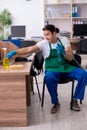 Young handsome contractor cleaning the office Royalty Free Stock Photo