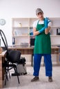 Young handsome contractor cleaning the office