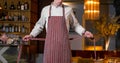 Young handsome cook chief tying apron in modern restaurant interior