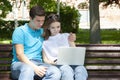 Young handsome couple using notebook in the public park Royalty Free Stock Photo