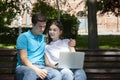 Young handsome couple using notebook in the public park Royalty Free Stock Photo