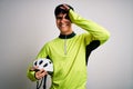 Young handsome cyclist man holding security bike helmet over isolated white background with happy face smiling doing ok sign with Royalty Free Stock Photo
