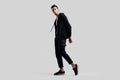 Young handsome dancer dressed in black pants and a sweatshirt on a naked torso stands on the white background Royalty Free Stock Photo