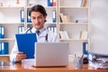 The young handsome doctor working in the clinic Royalty Free Stock Photo